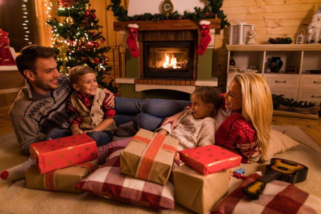 family laying on the floor with presents at Christmas time.