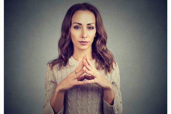 Woman standing with her fingers touching