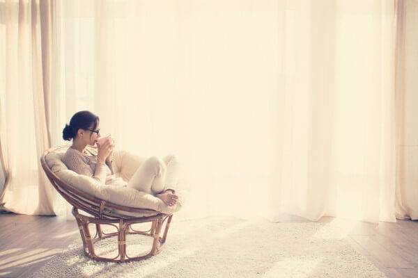 Women sitting in a room by herself drinking coffee