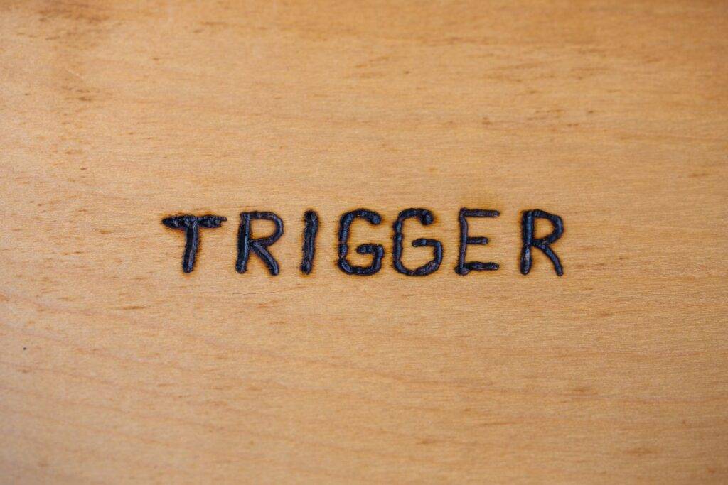 The word trigger burned into a piece of wood.