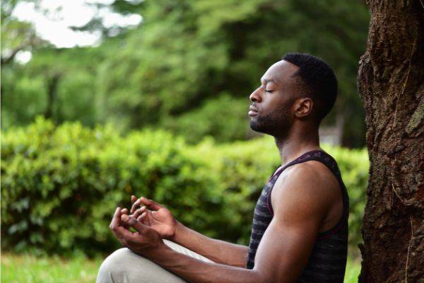 Man sitting by tree meditating