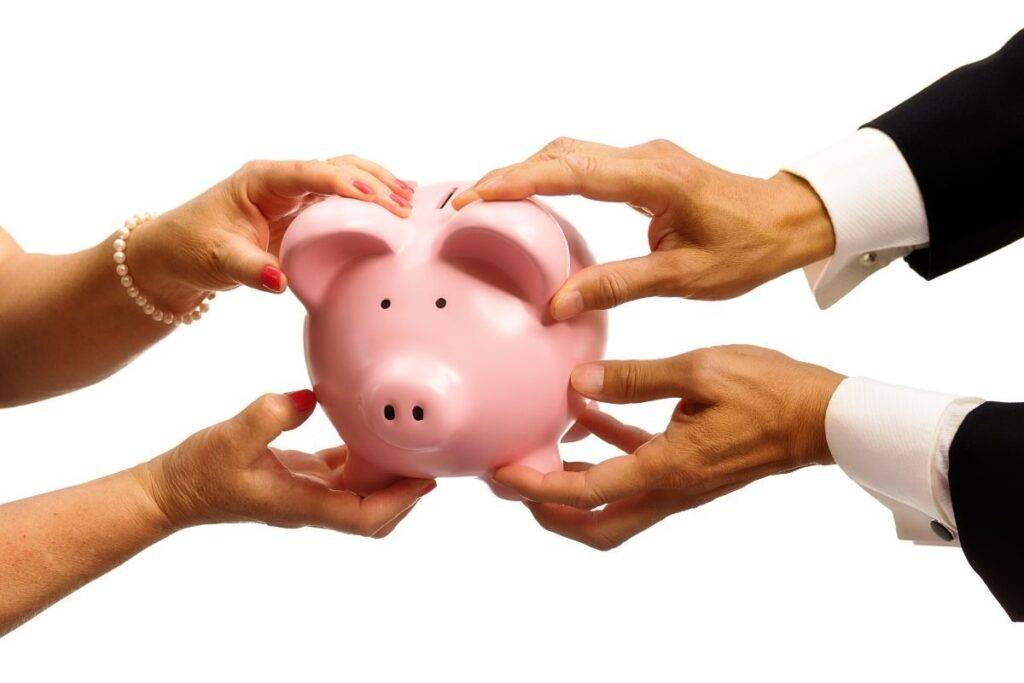 Man and woman holding a piggy bank.