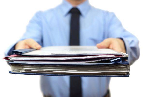 Man handing papers up towards camera