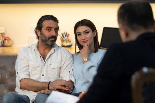 Man and woman sitting on couch talking to therapist.