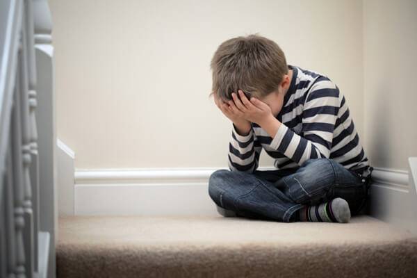 Boy sitting on the floor crying