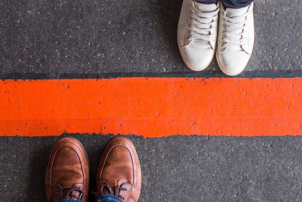 Man and woman stating on opposite sides of a line.