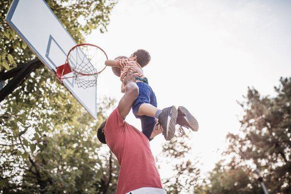 Father playing basketball with young son