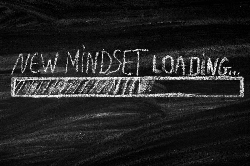 New Mindset Loading written on caulk board.