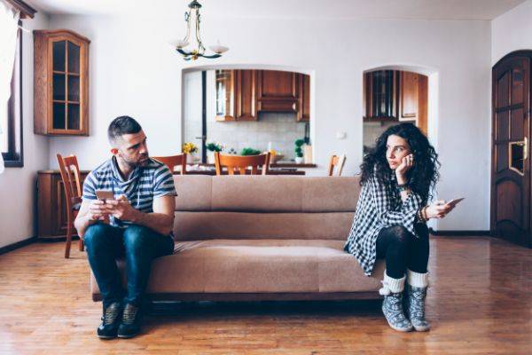 couple sitting on opposite ends of the couch