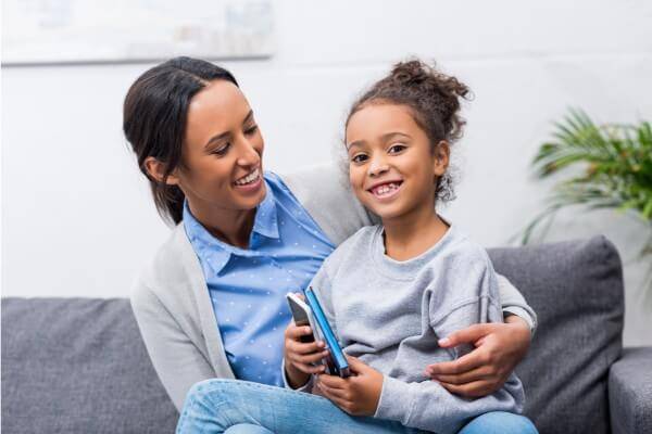 Mother sitting on couch with her daughter