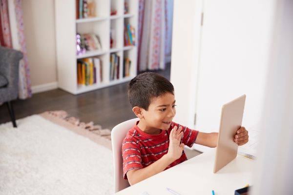 Young boy talking to someone using an tablet