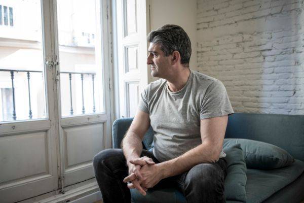 Man sitting on couch in apartment alone