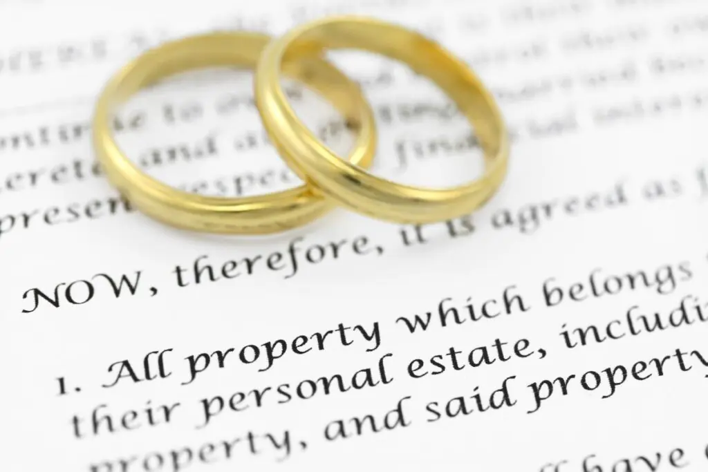 Martial settlement agreement on paper with two gold rings sitting on top.