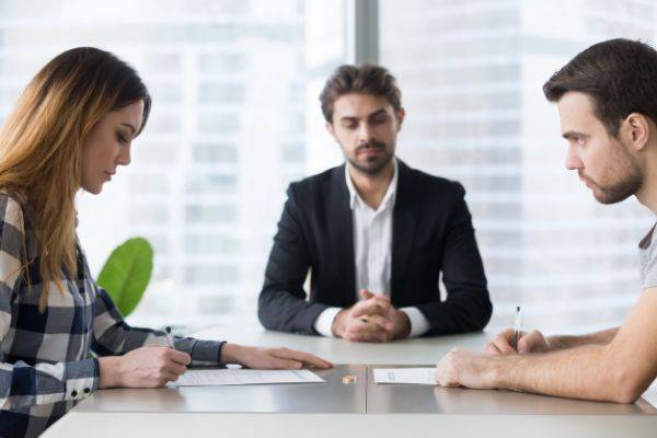 Couple sitting at a desk with a divorce lawyer