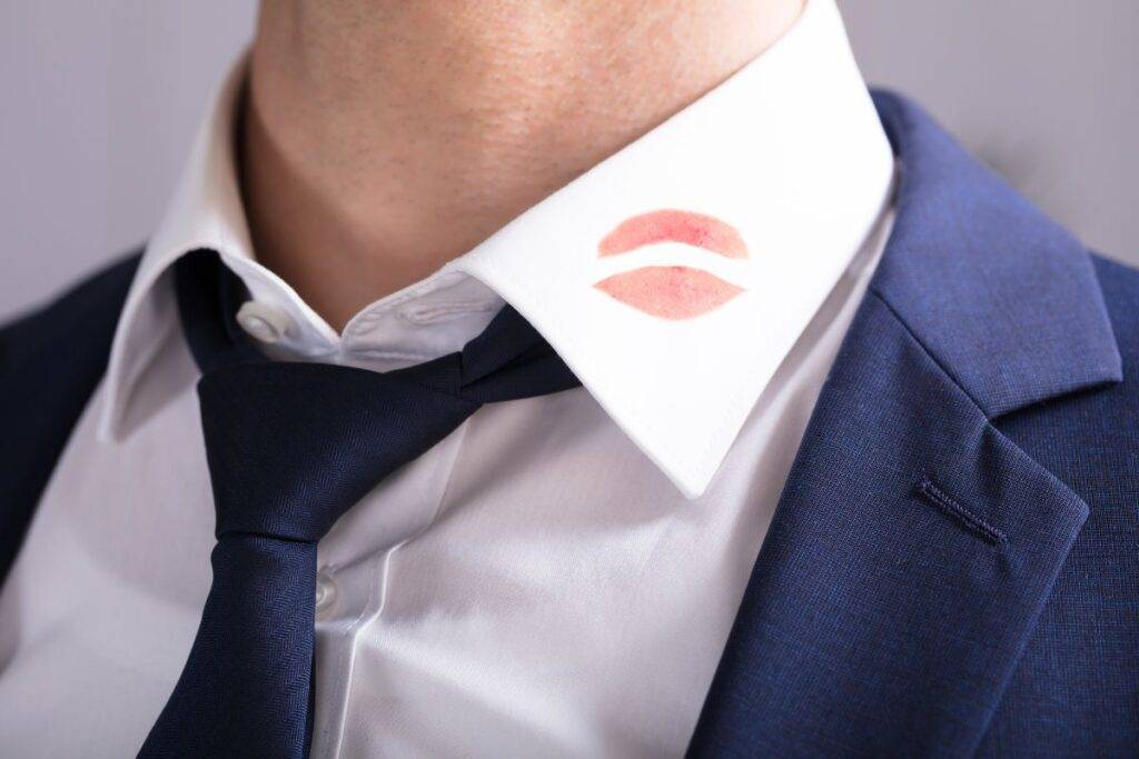 Man in suit with a lipstick kiss on his collar.