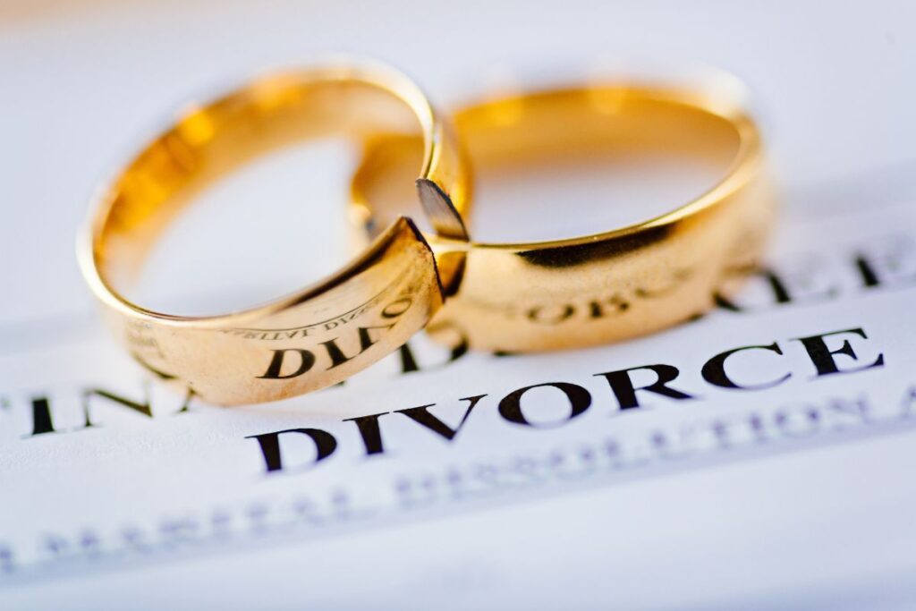 Divorce word on paper with two gold rings on top.