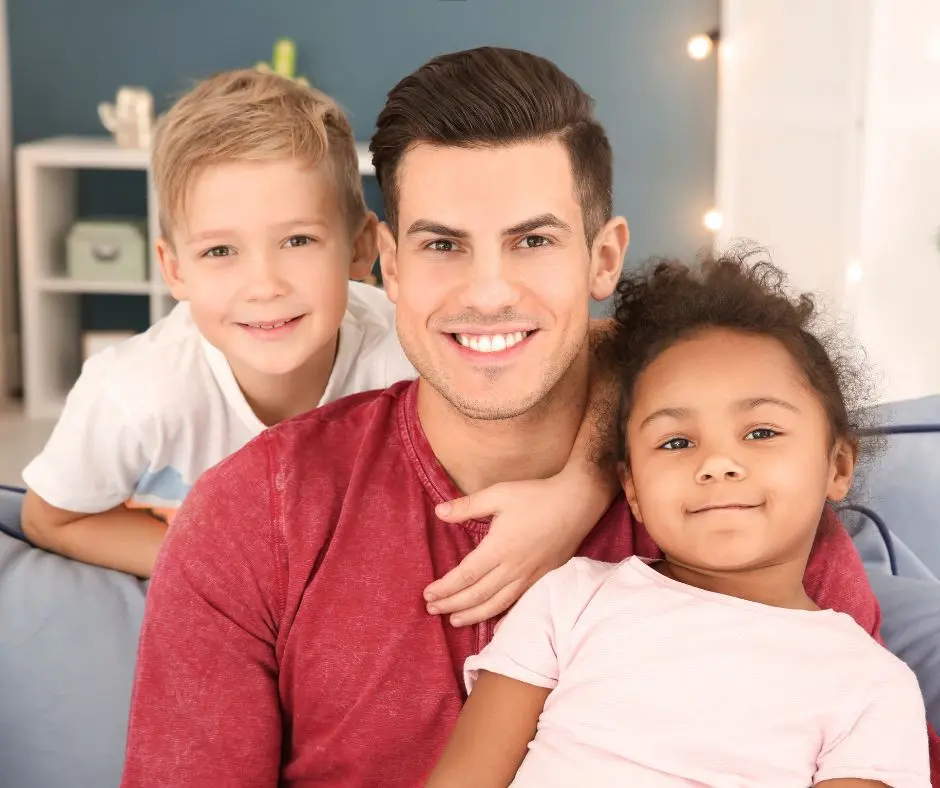 Fathers and Custody : A father lovingly pose for a picture opportunity with his kids