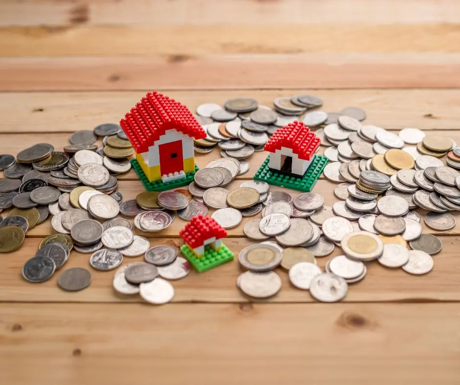 miniature houses in blocks are placed in the middle of coins
