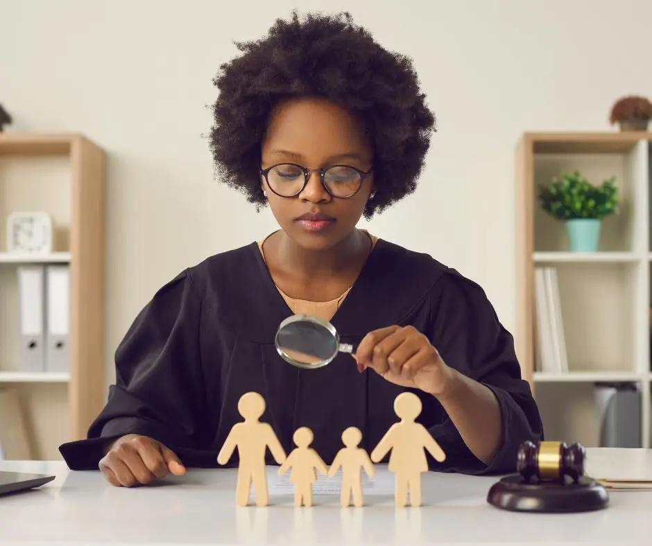 a guardian ad litem is observing a miniature family using a magnifying glass