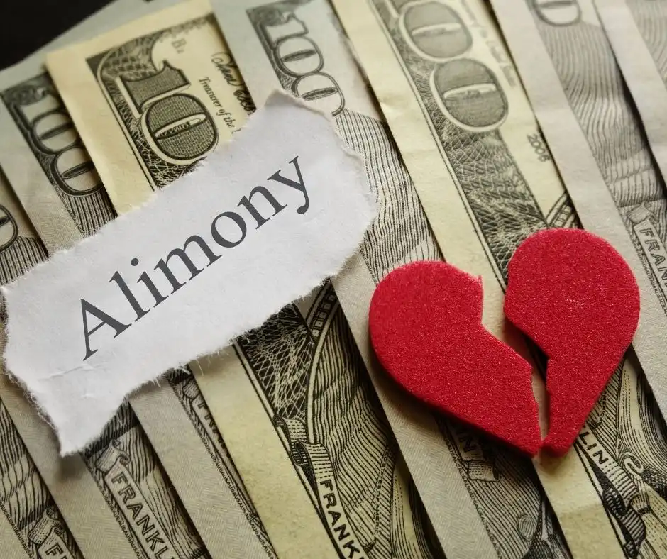 dollar bills laid on a table, a broken heart and a torn paper with word wisconsin alimony