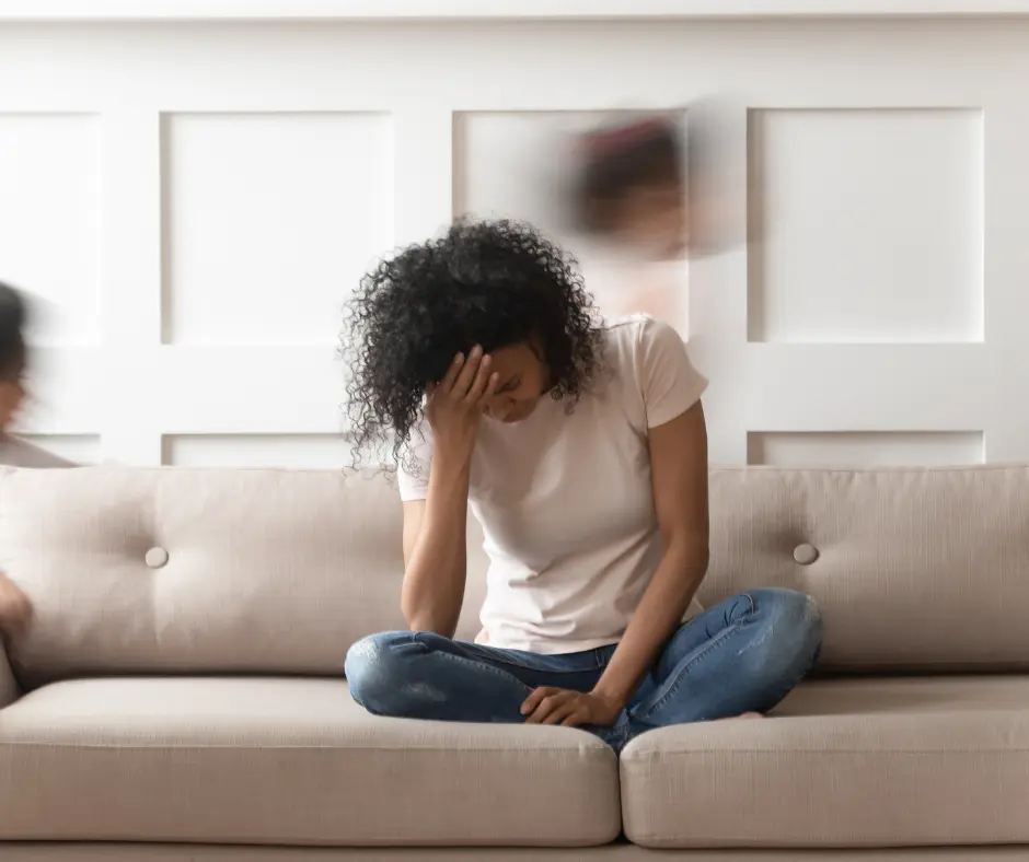 a woman is sitting at the sofa feeling divorce guilt